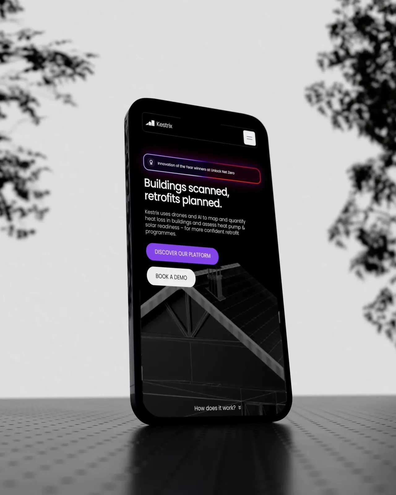 Smartphone showing the Kestrix website hero, Buildings scanned, retrofits planned, designed by Junca Studio