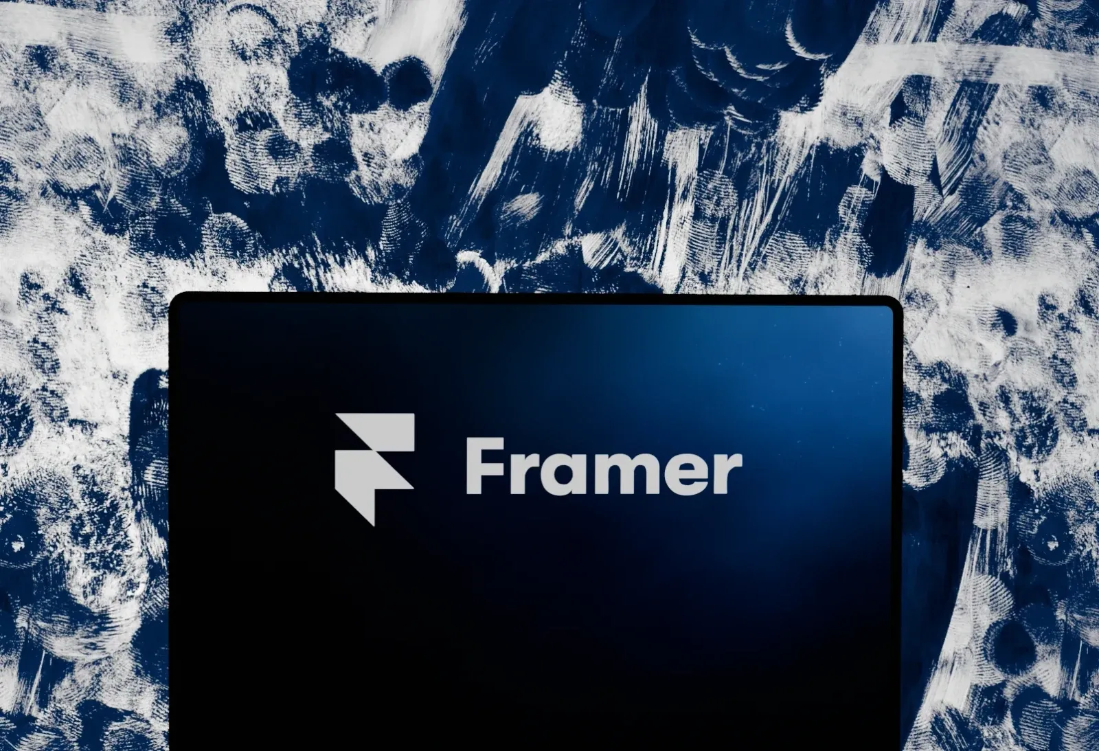 Laptop showing the Framer logo on a deep blue background
